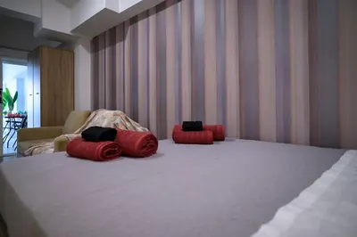 three red pillows on a bed in a room at Premium Athenian District Urban Studio in Athens