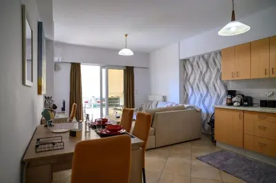 a kitchen and living room with a table and a couch at Premium Athenian District Urban 1 bedroom flat A in Athens