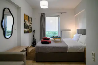 a bedroom with a bed and a table and a window at Premium Athenian District Urban 1 bedroom flat B in Athens