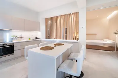 a kitchen with a white island in a room at Oculus Kallithea Creators Hub&Suite by Live&Travel in Athens