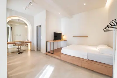 a white bedroom with a bed and a desk at Oculus Kallithea Creators Hub&Suite by Live&Travel in Athens
