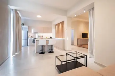 a kitchen and living room with a couch and a table at Oculus Kallithea Creators Hub&Suite by Live&Travel in Athens