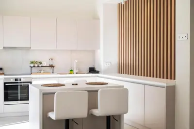 a white kitchen with white cabinets and white chairs at Oculus Kallithea Creators Hub&Suite by Live&Travel in Athens