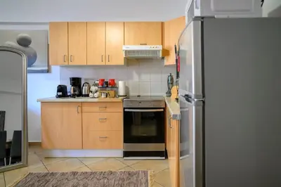 a kitchen with wooden cabinets and a stainless steel refrigerator at Premium Athenian District Urban 1 bedroom Flat D in Athens