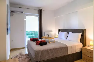 a bedroom with a large bed with a large window at Premium Athenian District Urban 1 bedroom Flat D in Athens
