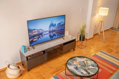 a living room with a large flat screen tv at Fresh&comfy4family & friends in Athens