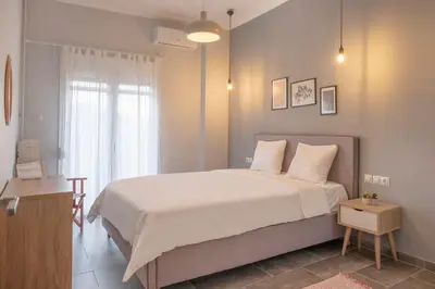 a bedroom with a large white bed and a window at Fresh&comfy4family & friends in Athens