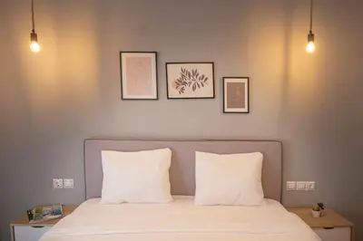 a bed with two pillows and three pictures on the wall at Fresh&comfy4family & friends in Athens