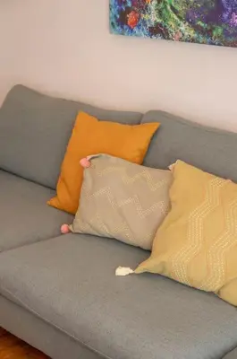 a gray couch with pillows on top of it at Fresh&comfy4family & friends in Athens