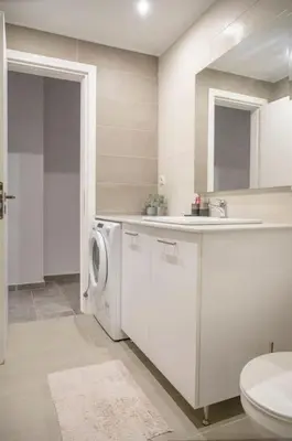 a bathroom with a washing machine and a sink at Fresh&comfy4family & friends in Athens