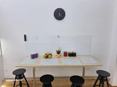 a table with chairs and a clock on a wall at AS luxury apartment in Athens