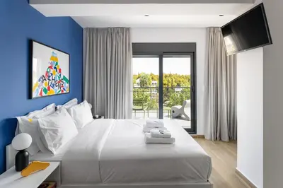 a bedroom with a white bed with a blue wall at Fits Living in Athens