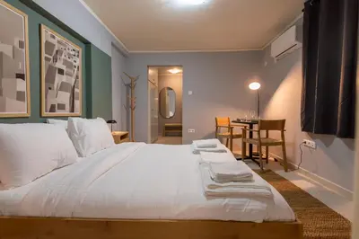 a bedroom with a large white bed and a table at Zen Athens City Center in Athens