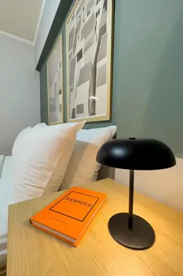 an orange and black stool sitting on a table next to a bed at Zen Athens City Center in Athens