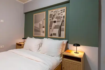 a bedroom with a bed and two tables with lamps at Zen Athens City Center in Athens