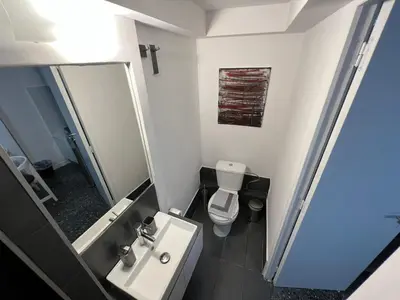 a bathroom with a sink and a toilet and a mirror at Ground floor appartment Panormou Metro in Athens