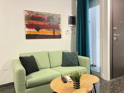 a living room with a green couch and a table at Ground floor appartment Panormou Metro in Athens