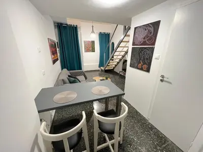 a living room with a table and chairs at Ground floor appartment Panormou Metro in Athens