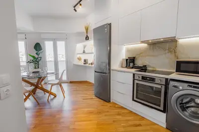 a kitchen with white cabinets and a washer and dryer at Penthouse Nest for 3 persons in Athens