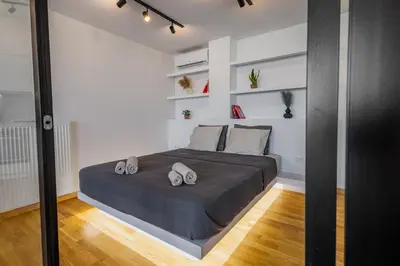 a bedroom with a large bed and white walls at Penthouse Nest for 3 persons in Athens