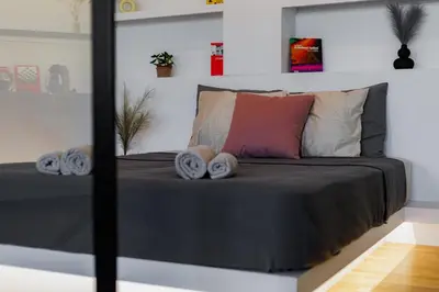 a bedroom with a black bed with pillows at Penthouse Nest for 3 persons in Athens