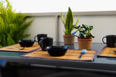 a table with three bowls and spoons and plants at Penthouse Nest for 3 persons in Athens