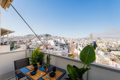 a balcony with tables and a view of the city at Penthouse Nest for 3 persons in Athens