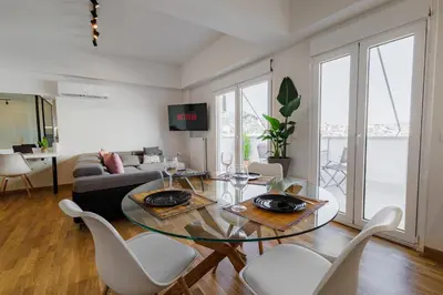 a living room with a glass table and white chairs at Penthouse Nest for 3 persons in Athens