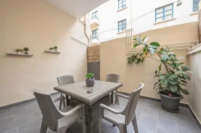 a table and chairs on a balcony with a plant at Peaceful and comfy 2BA in Athens heart in Athens