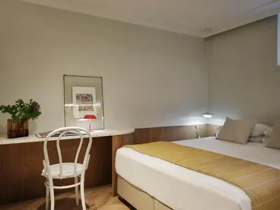 a bedroom with a bed and a chair in it at Presidential Suites, by Athens Stay in Athens