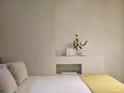 a white bedroom with a bed with a plant on it at Presidential Suites, by Athens Stay in Athens