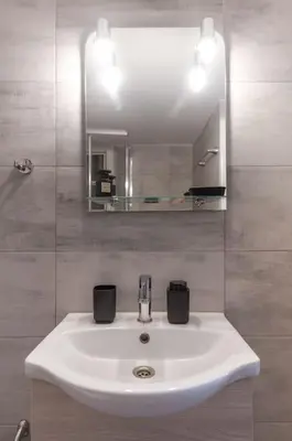 a bathroom with a white sink and a mirror at Renovated Gem near Pedion Areos Park & Museums in Athens