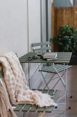 a table with a laptop and a blanket on a chair at Renovated Gem near Pedion Areos Park & Museums in Athens