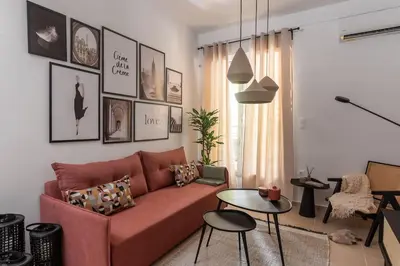 a living room with a red couch and a table at Renovated Gem near Pedion Areos Park & Museums in Athens