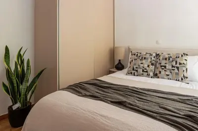 a bedroom with a bed with a pillow and a plant at Renovated Gem near Pedion Areos Park & Museums in Athens