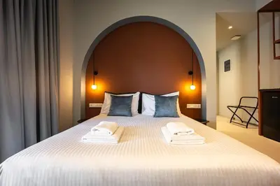 a bedroom with a large bed with two towels on it at Arches Apartments in Athens