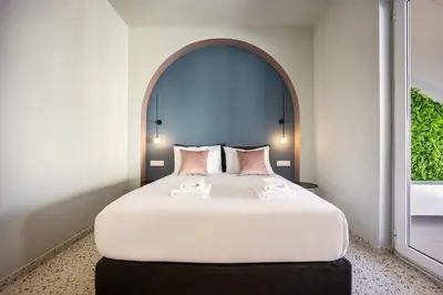 a bedroom with a large bed with an arch above it at Arches Apartments in Athens