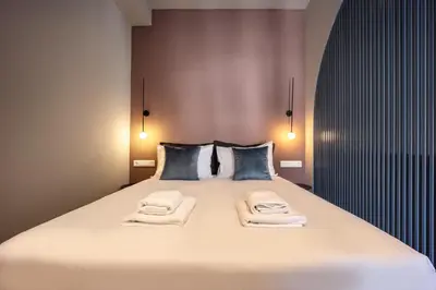 a bedroom with a large bed with towels on it at Arches Apartments in Athens