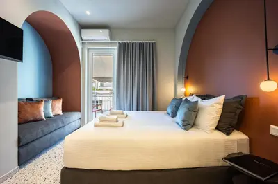 a bedroom with a large bed and a couch at Arches Apartments in Athens