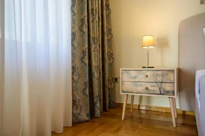 a lamp on a table next to a curtain at Blue Ark Acropolis Signature Residence in Athens
