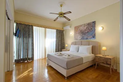 a bedroom with a bed and a ceiling fan at Blue Ark Acropolis Signature Residence in Athens