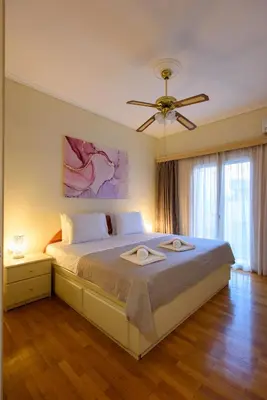 a bedroom with a large bed with a ceiling fan at Blue Ark Acropolis Signature Residence in Athens