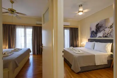 a hotel room with two beds and a ceiling fan at Blue Ark Acropolis Signature Residence in Athens