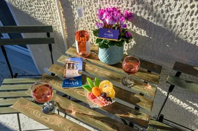 a table with wine glasses and a vase of flowers at Blue Ark Acropolis Signature Residence in Athens