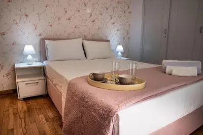 a bed with a tray with two glasses on it at Penthouse archeol musiem, 3BDR, big balcony, wifi 200 mbps fiber in Athens
