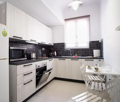 a kitchen with white cabinets and a table in it at Penthouse archeol musiem, 3BDR, big balcony, wifi 200 mbps fiber in Athens