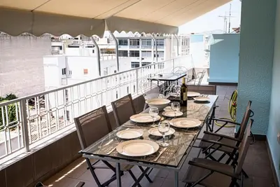 a table with plates and wine glasses on a balcony at Penthouse archeol musiem, 3BDR, big balcony, wifi 200 mbps fiber in Athens