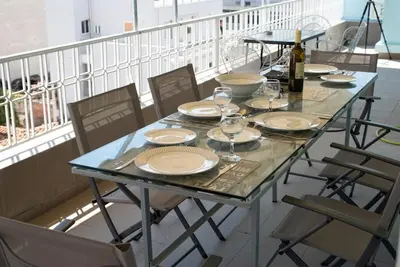 a table with plates and wine glasses on a balcony at Penthouse archeol musiem, 3BDR, big balcony, wifi 200 mbps fiber in Athens