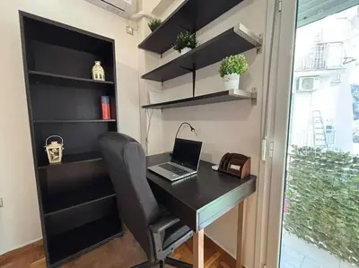 a desk with a laptop and a chair in a room at Downtown Pagrati Modern Apartment in Athens