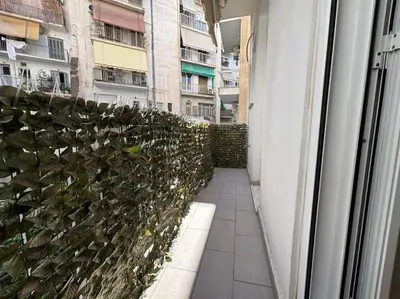 a hallway of a building with a fence at Downtown Pagrati Modern Apartment in Athens